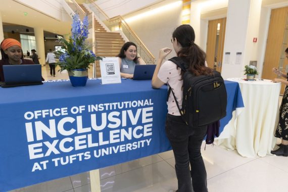A staff member from the Office of the Vice Provost for Institutional Inclusive Excellence has an informational table at an event.